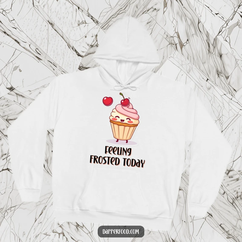 Funny hoodie design of a blushing cupcake with frosting and sprinkles, playfully tossing a cherry, radiating happiness.